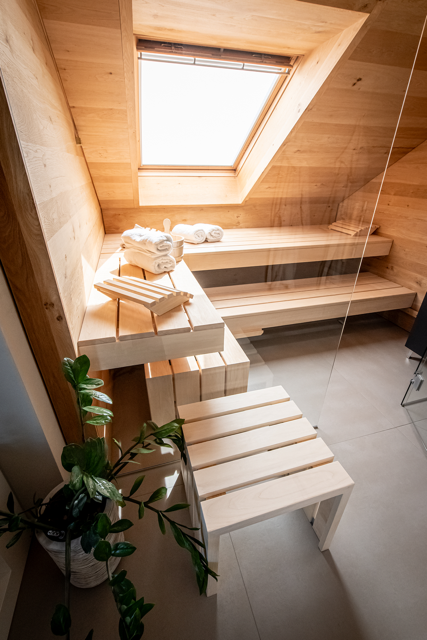 Un sauna en bois avec un puits de lumière et un banc.