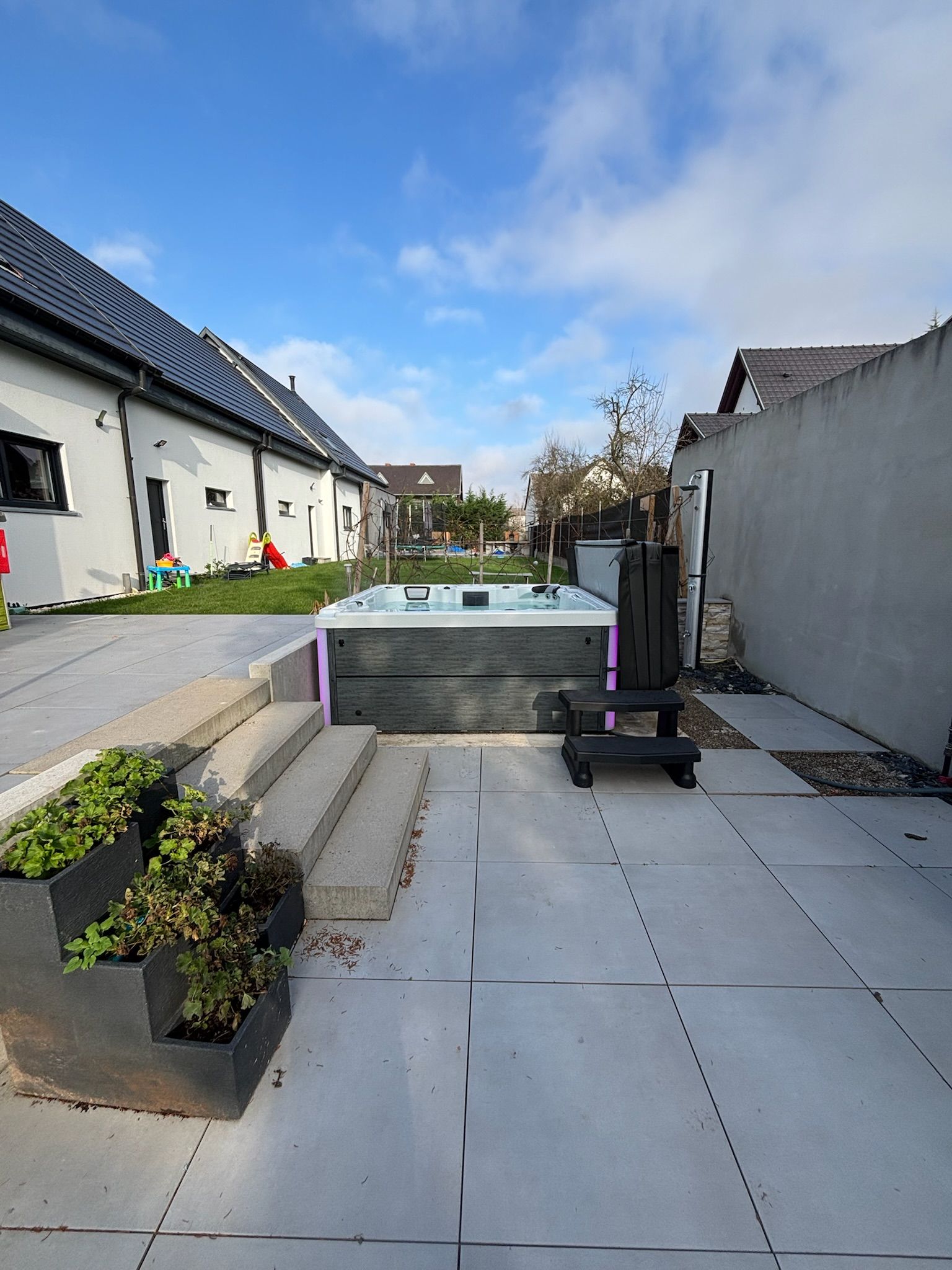 Un patio avec un jacuzzi au milieu