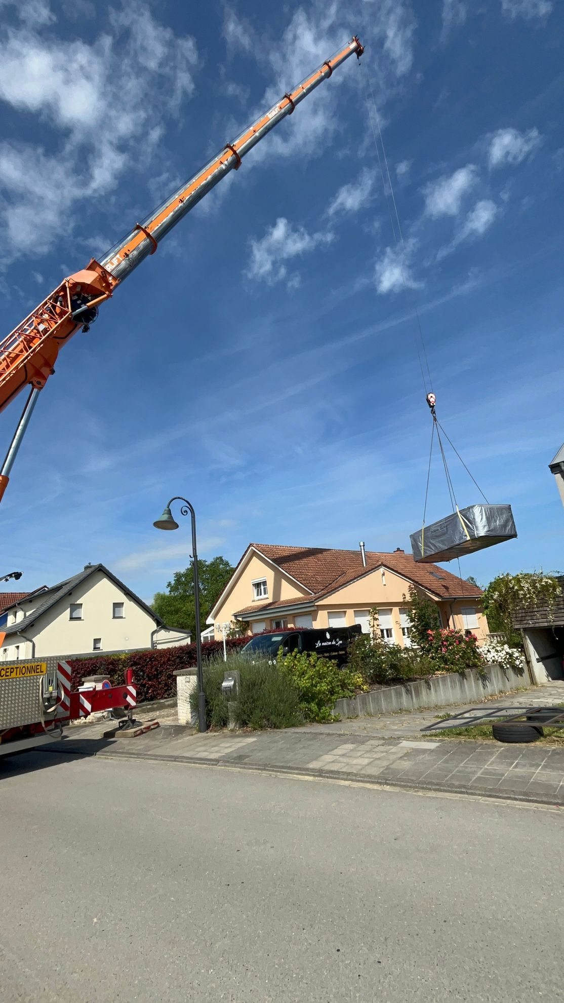 Une grue soulève un gros morceau de métal dans les airs.