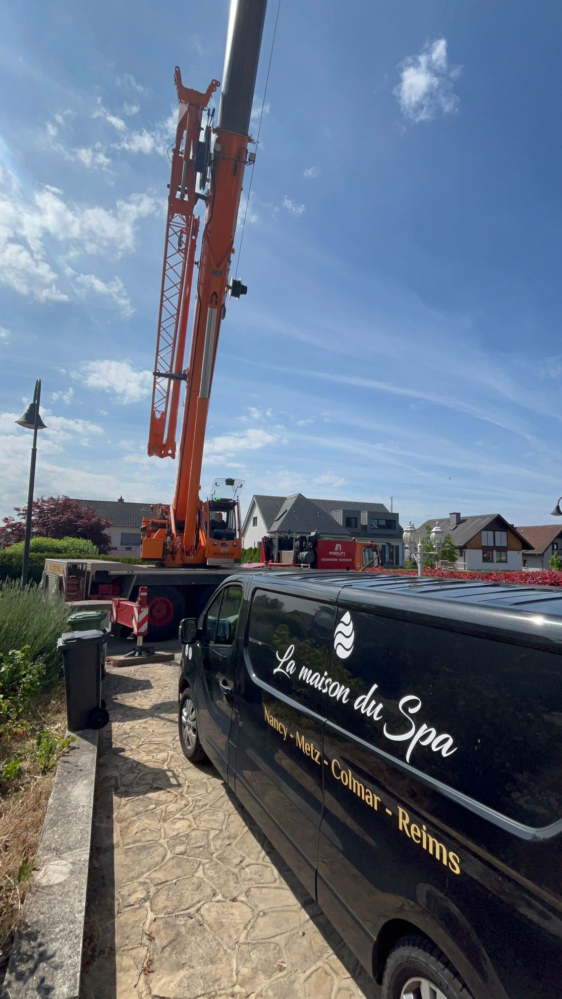Une grande grue est posée sur une camionnette noire.