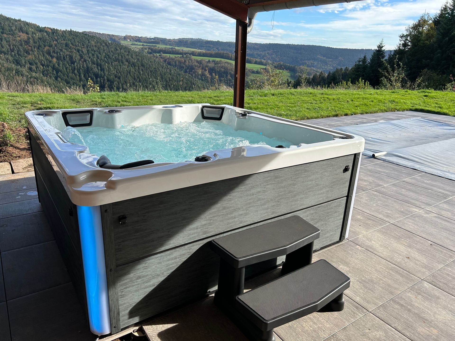 Un bain à remous est posé sur une terrasse en bois.