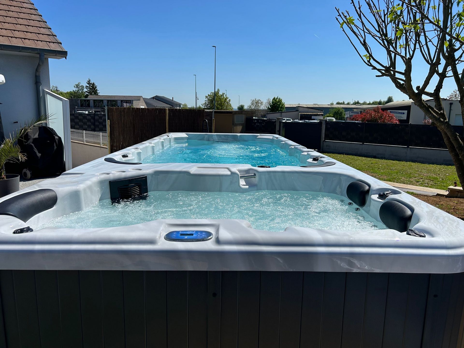 Un grand bain à remous se trouve dans l'arrière-cour d'une maison.