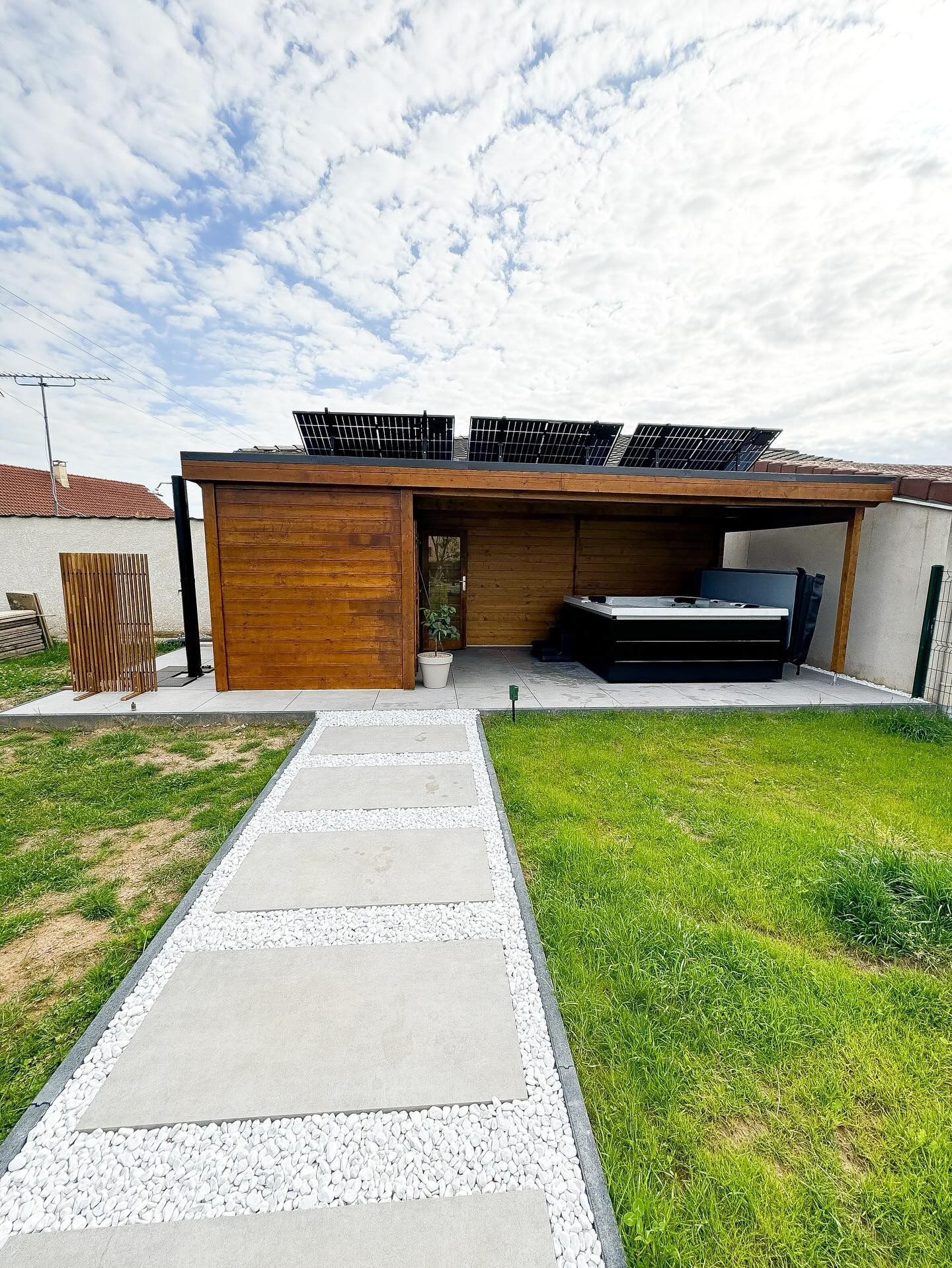 Il y a une passerelle menant à une maison avec un bain à remous dans l'arrière-cour.