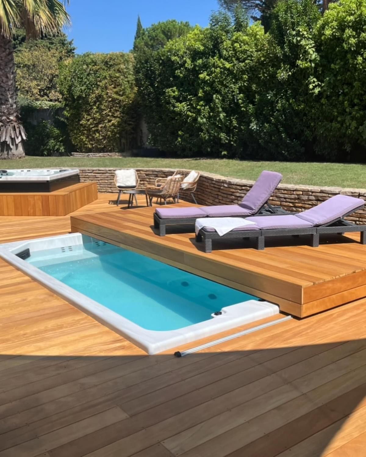 Une terrasse en bois avec piscine et chaises longues