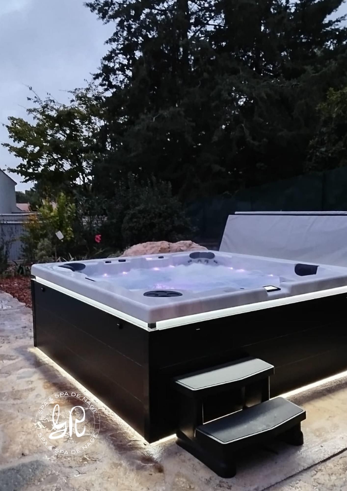 Un jacuzzi noir et blanc avec des escaliers qui y mènent