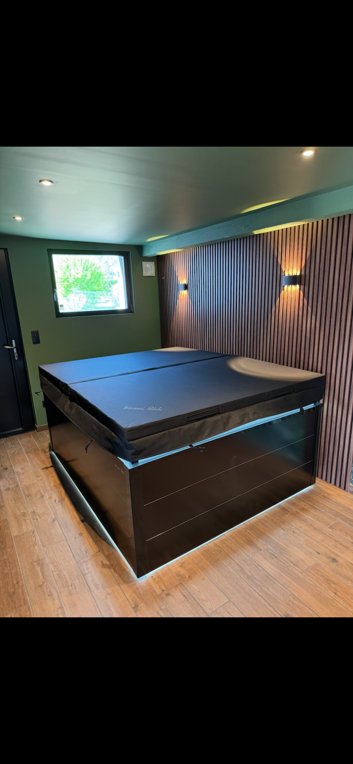 Une table de billard noire est posée dans une pièce à côté d'une fenêtre.