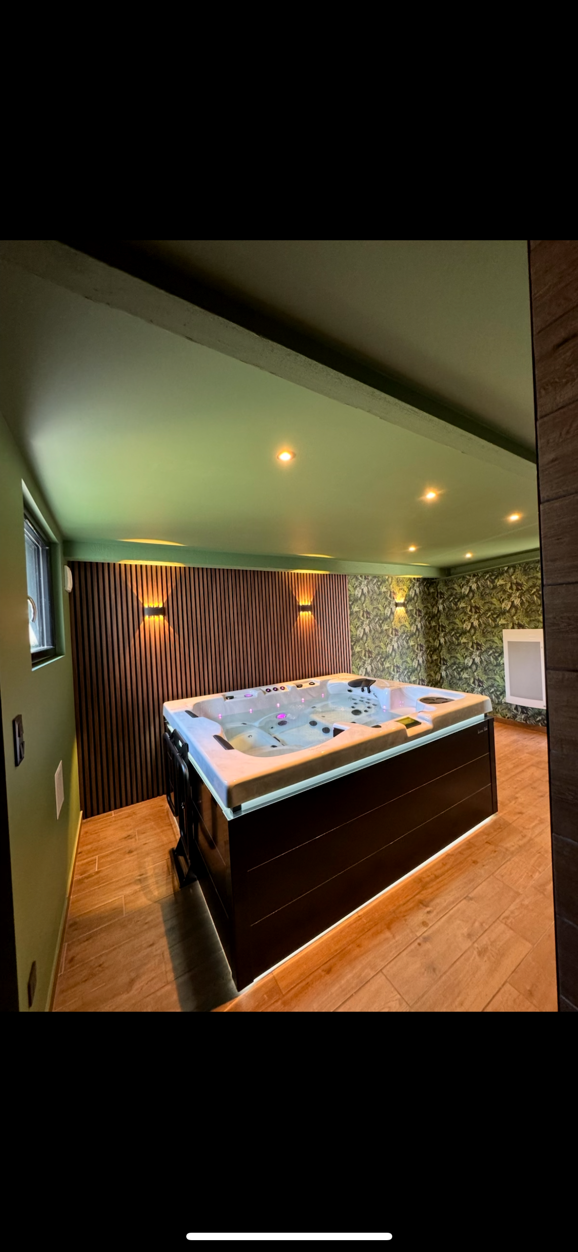 Il y a un grand jacuzzi au milieu de la pièce.