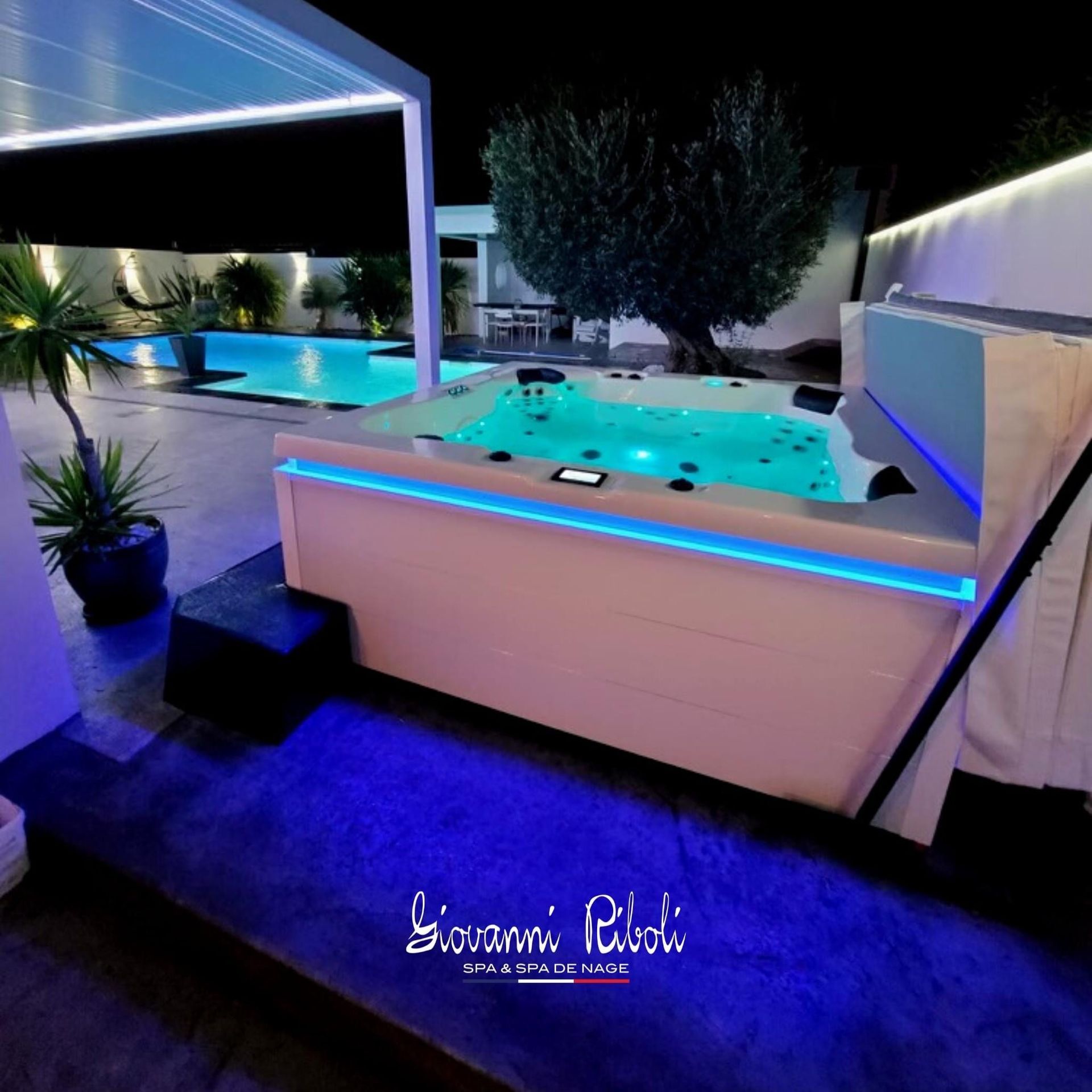 Un jacuzzi blanc est éclairé par des lumières bleues