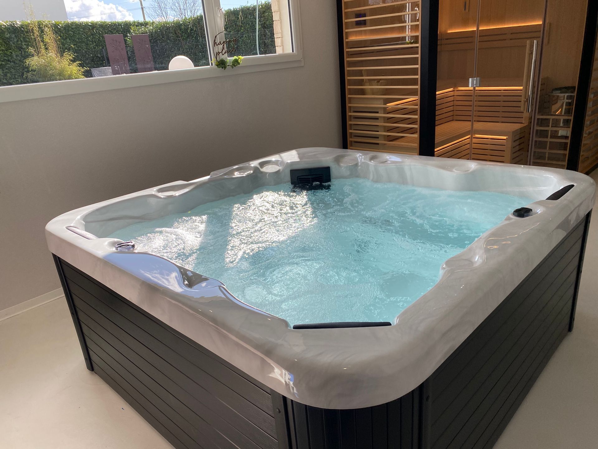 Un bain à remous est installé dans une pièce à côté d'une fenêtre.