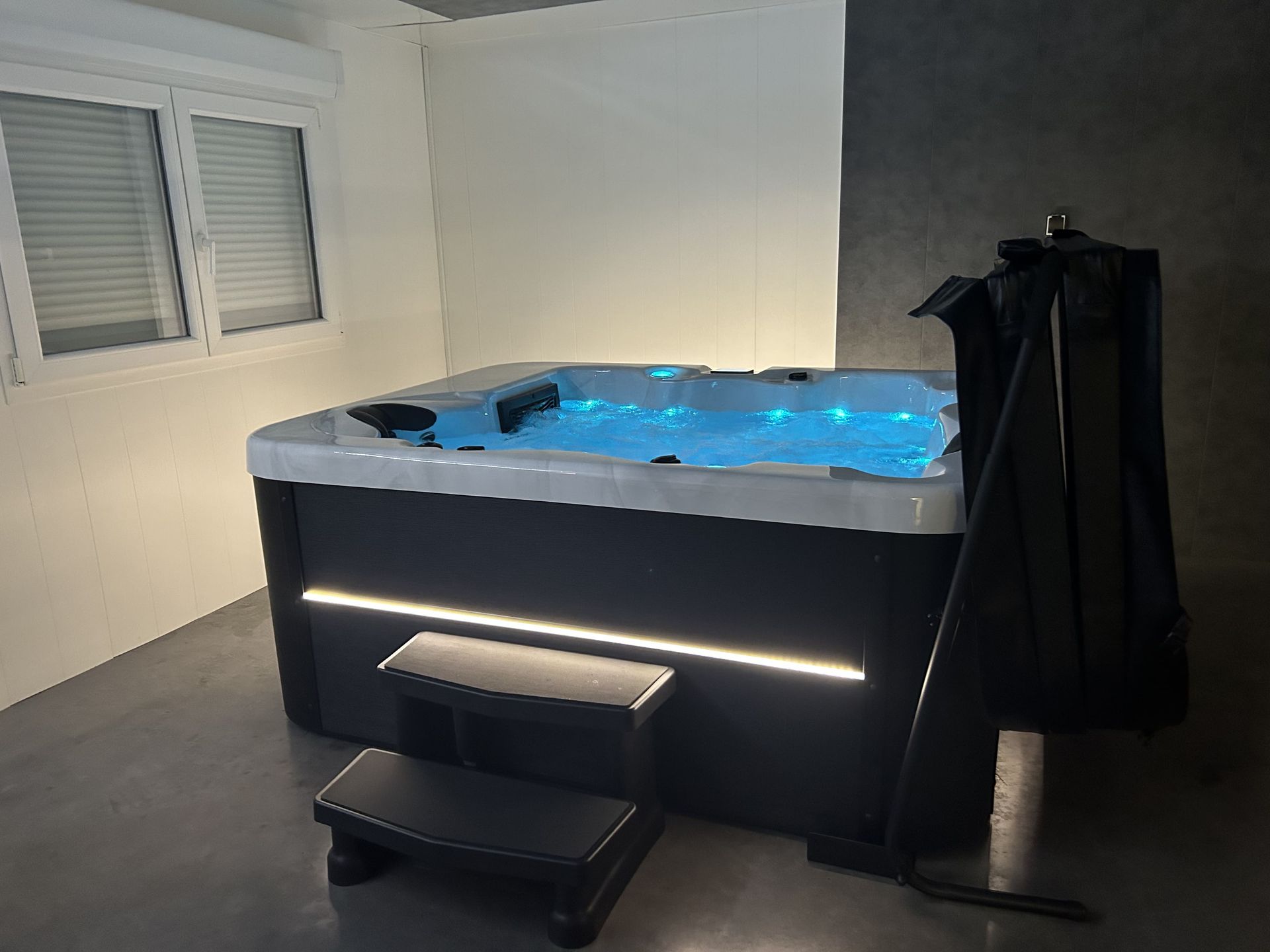 Un bain à remous est installé dans une pièce à côté d'une fenêtre.