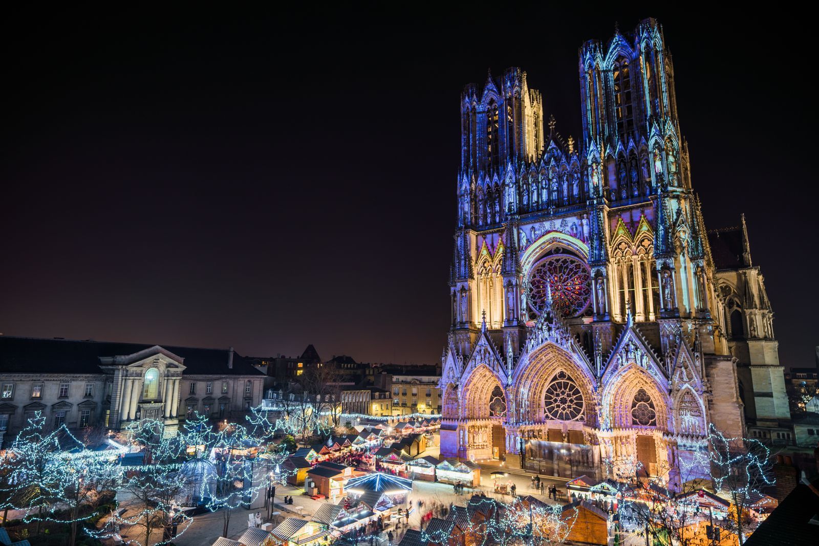 Cathédrale de Reims éclairée la nuit. Magasin de spa à Reims en cours d'ouverture.