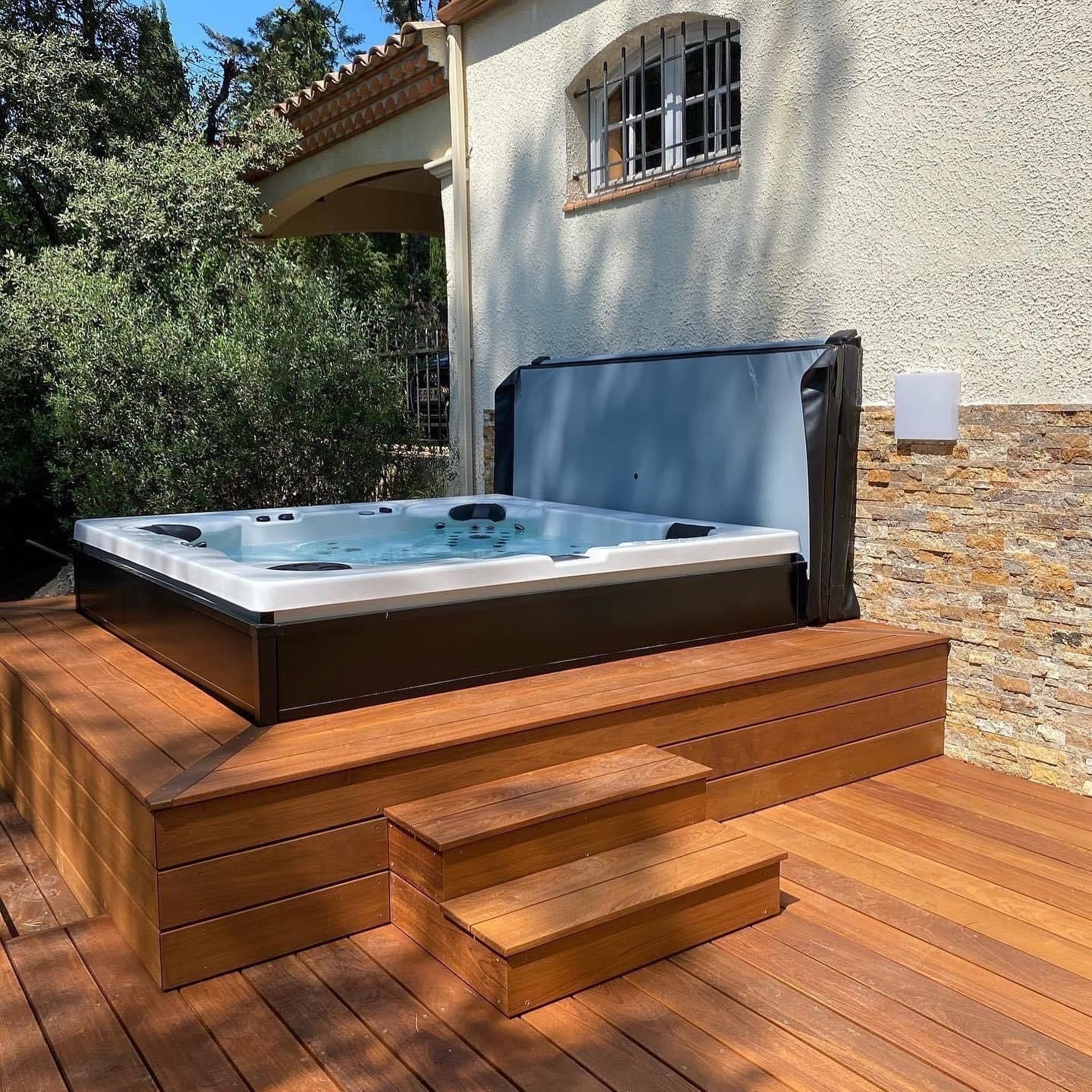 Un bain à remous est posé sur une terrasse en bois.
