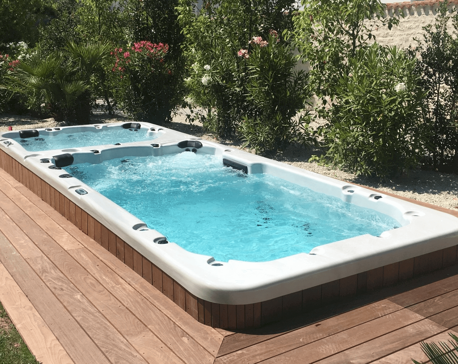 Une grande piscine est située sur une terrasse en bois.