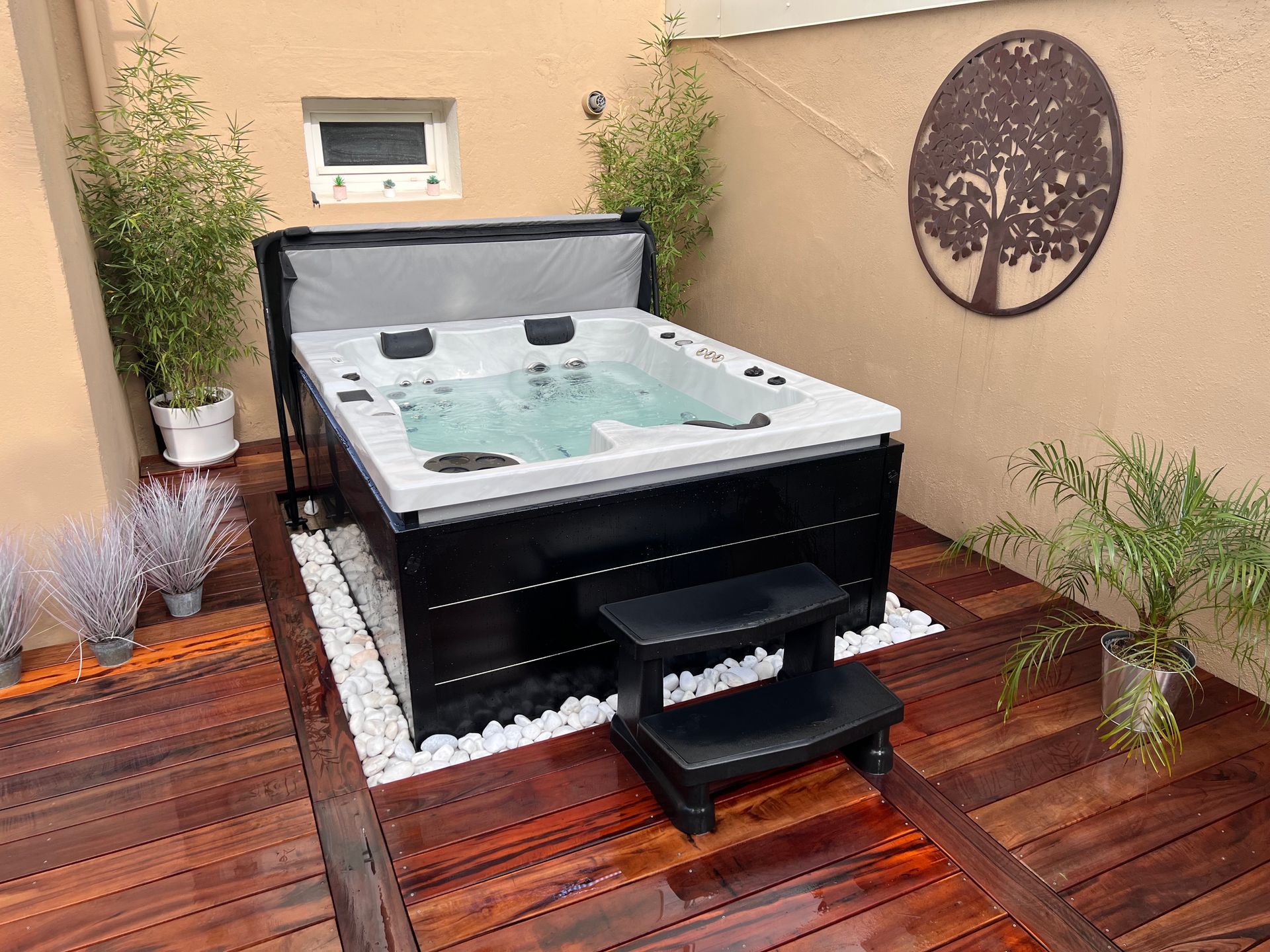 Un bain à remous est posé sur une terrasse en bois.