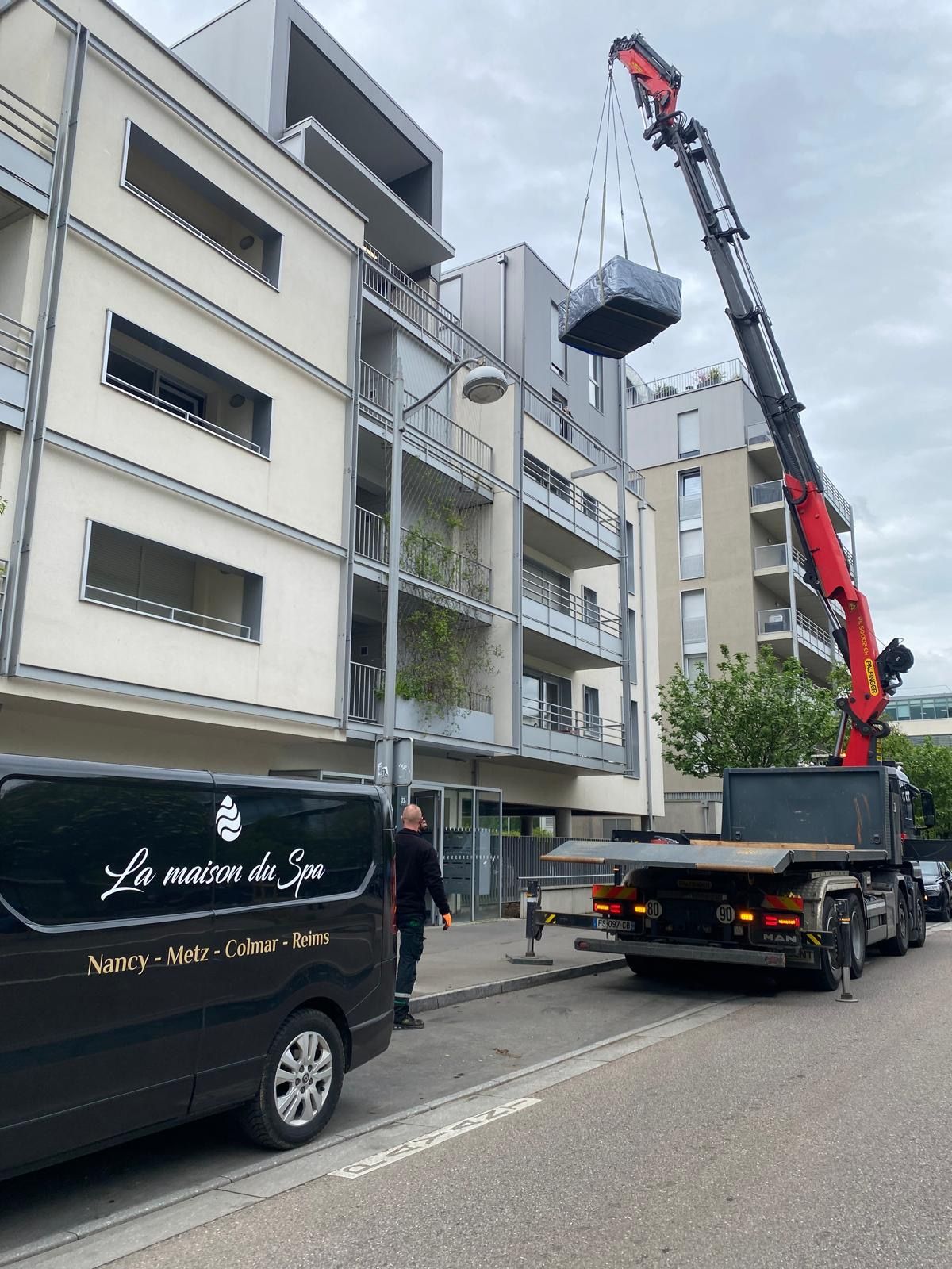 Une camionnette noire est garée devant un immeuble
