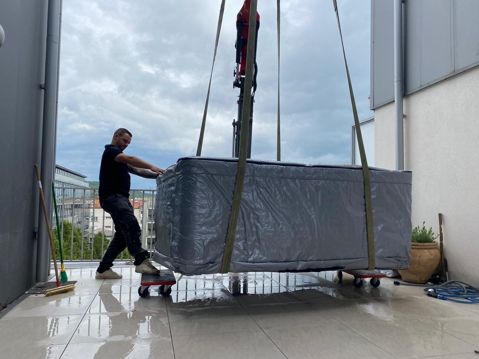 Un homme soulève un jacuzzi avec une grue.