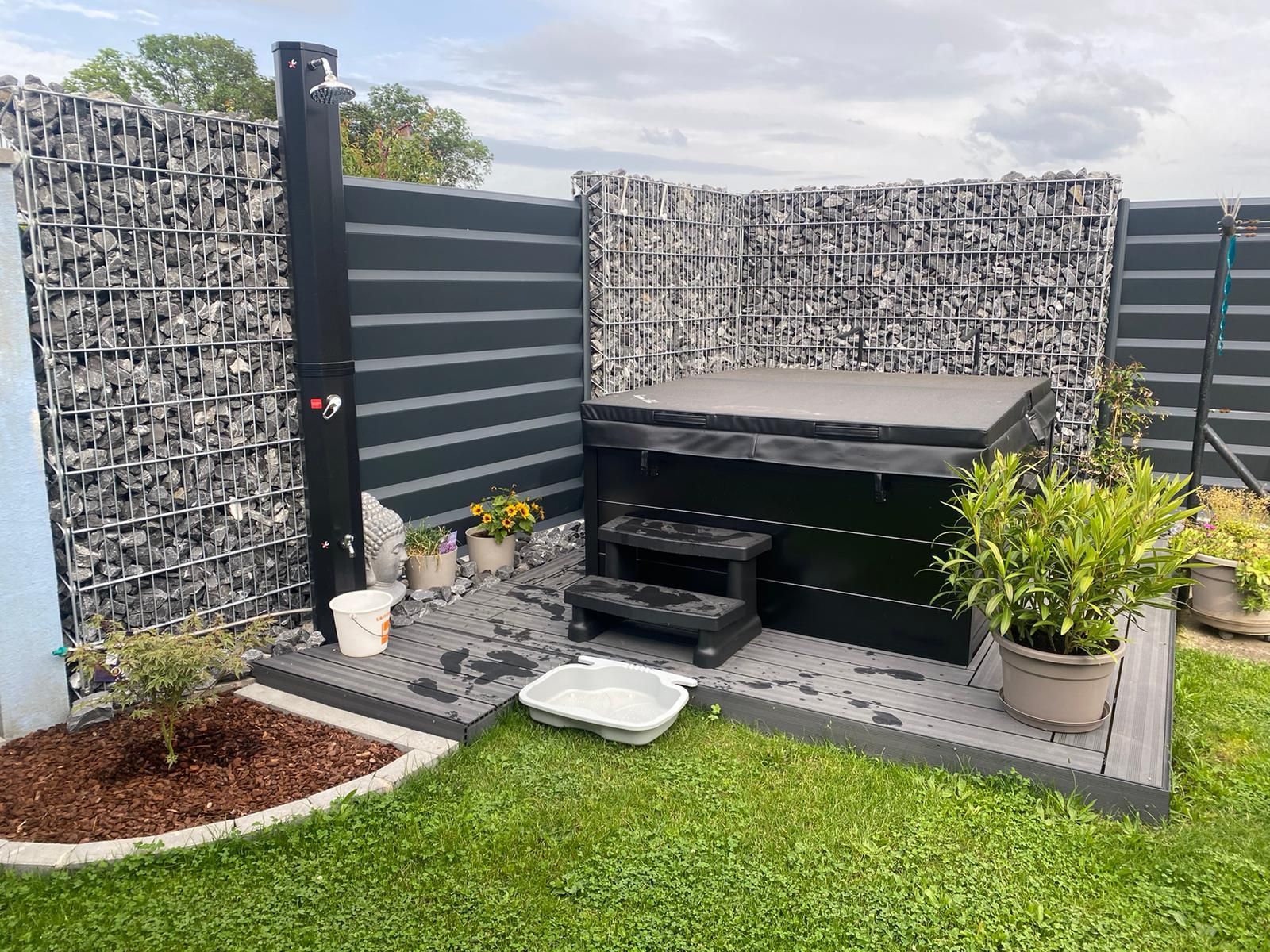 Une cour arrière avec un bain à remous et une douche.