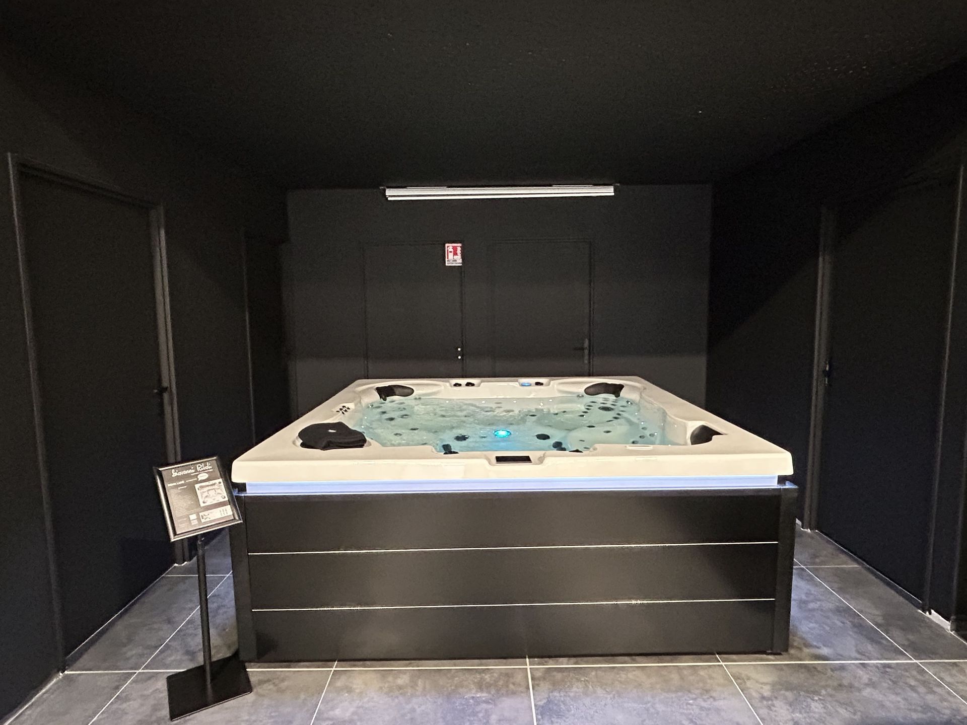 Un jacuzzi noir et blanc dans une pièce sombre