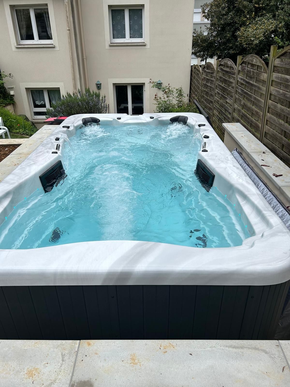 Une grande piscine se trouve dans l'arrière-cour d'une maison.
