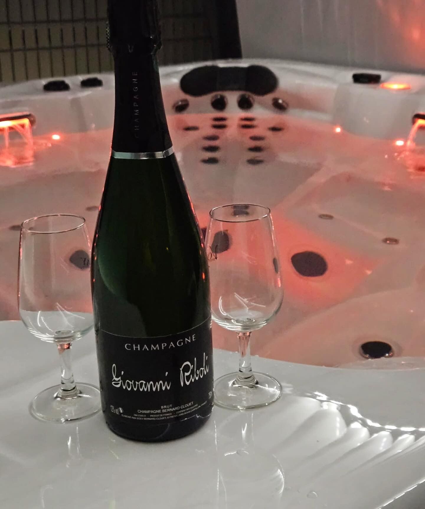 Une bouteille de champagne se trouve devant un jacuzzi