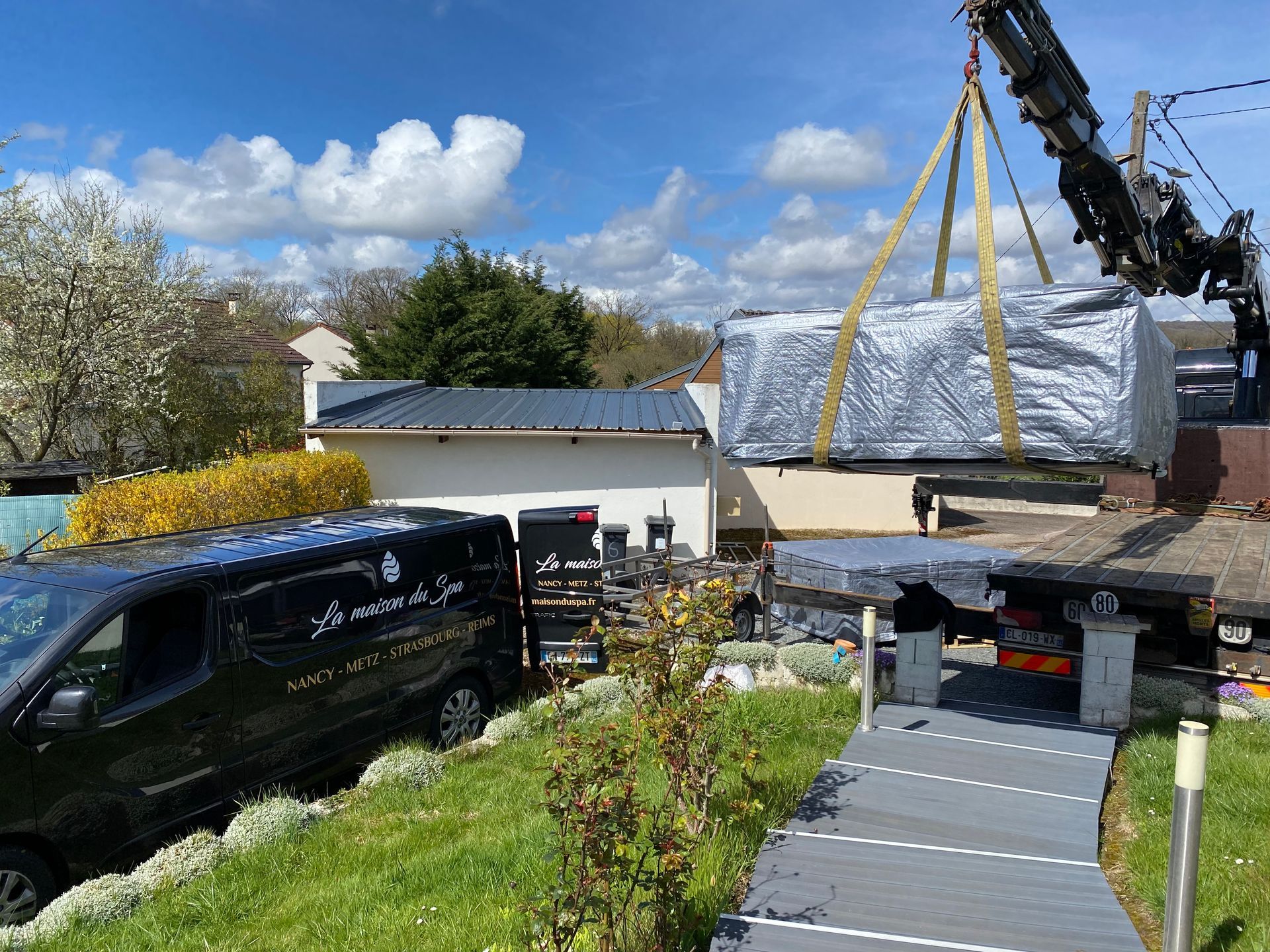 Une grue soulève un gros morceau de métal sur le dessus d'un camion.