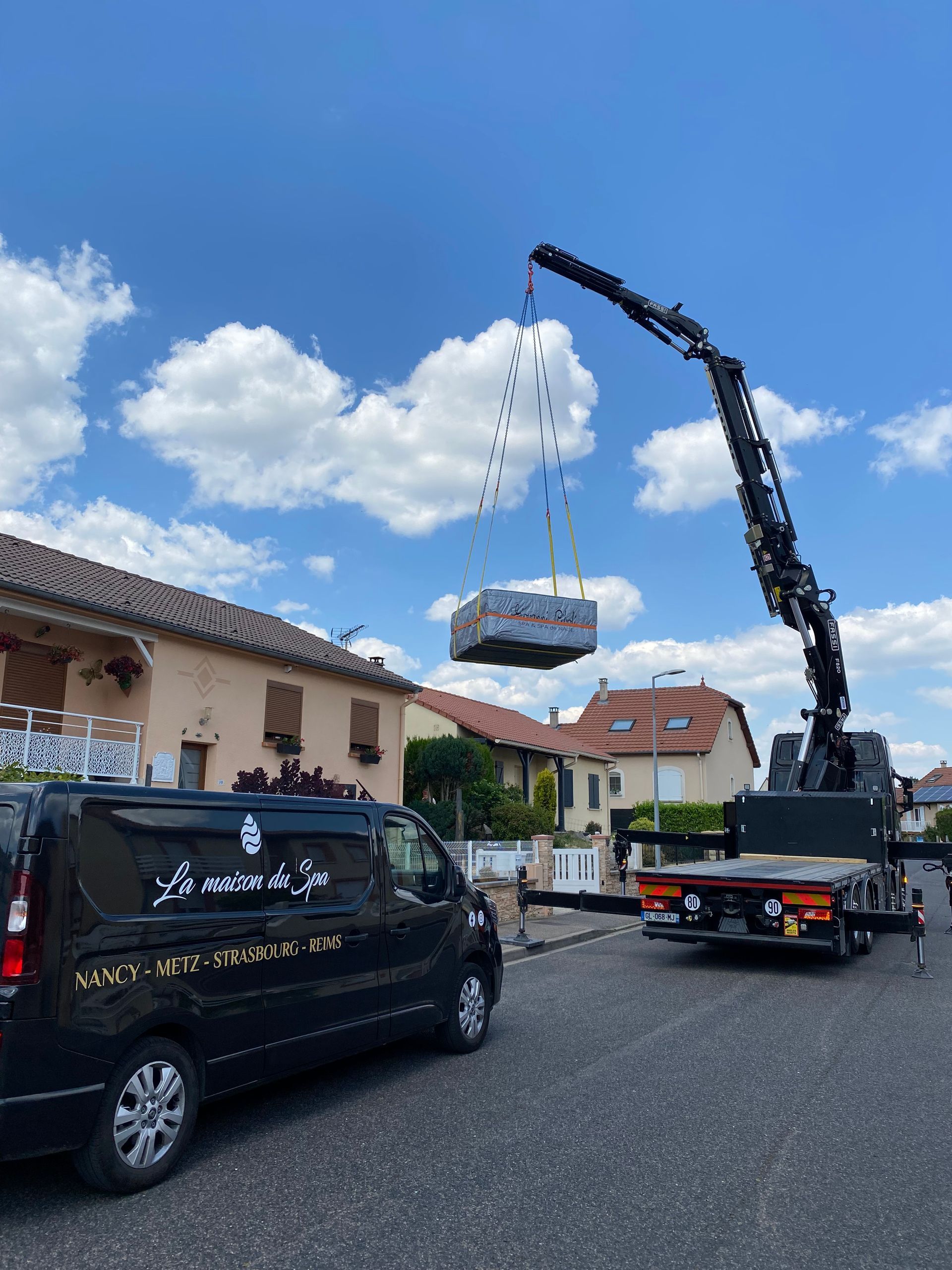 Une grue soulève une grande boîte dans les airs.