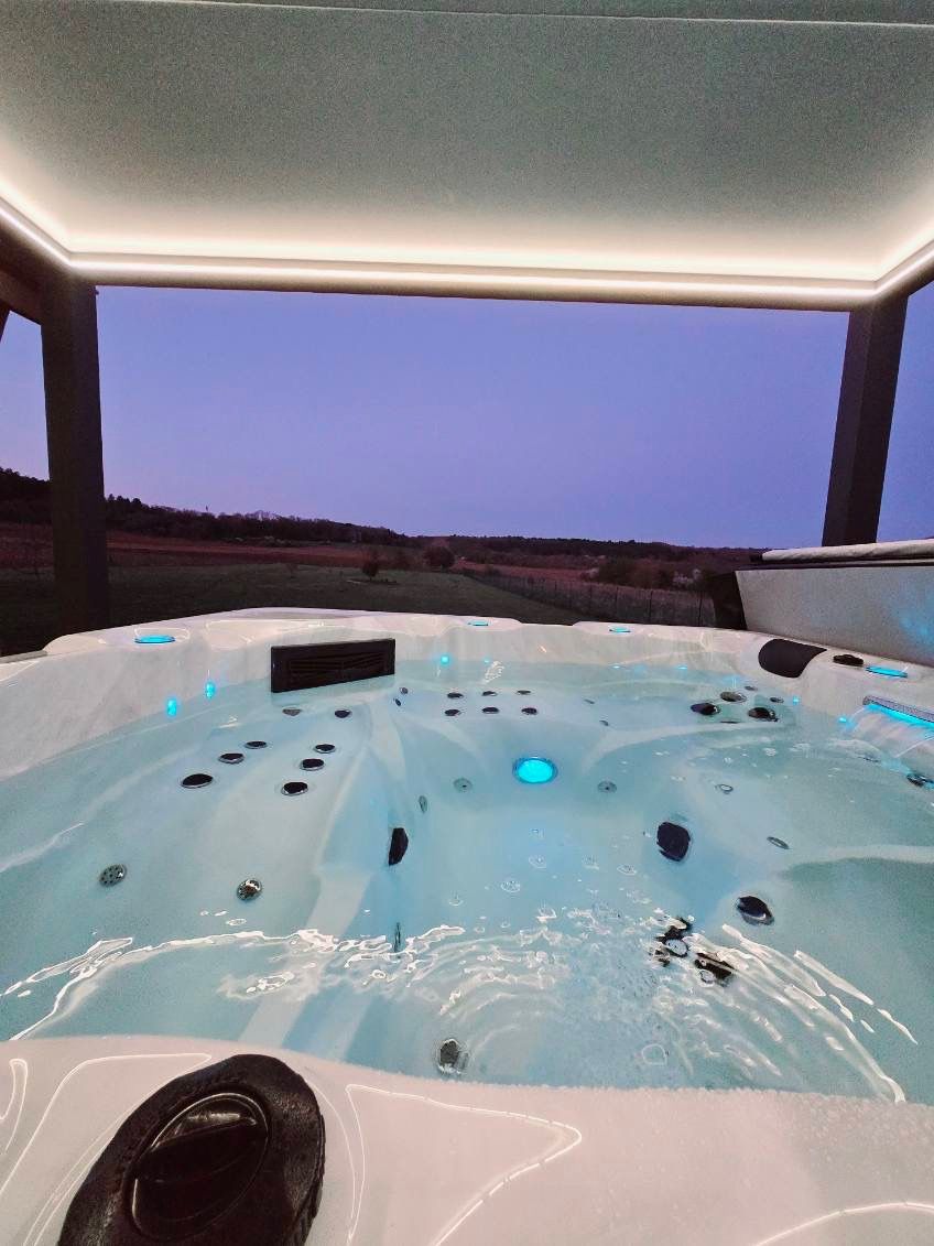 Un jacuzzi avec vue sur un champ la nuit