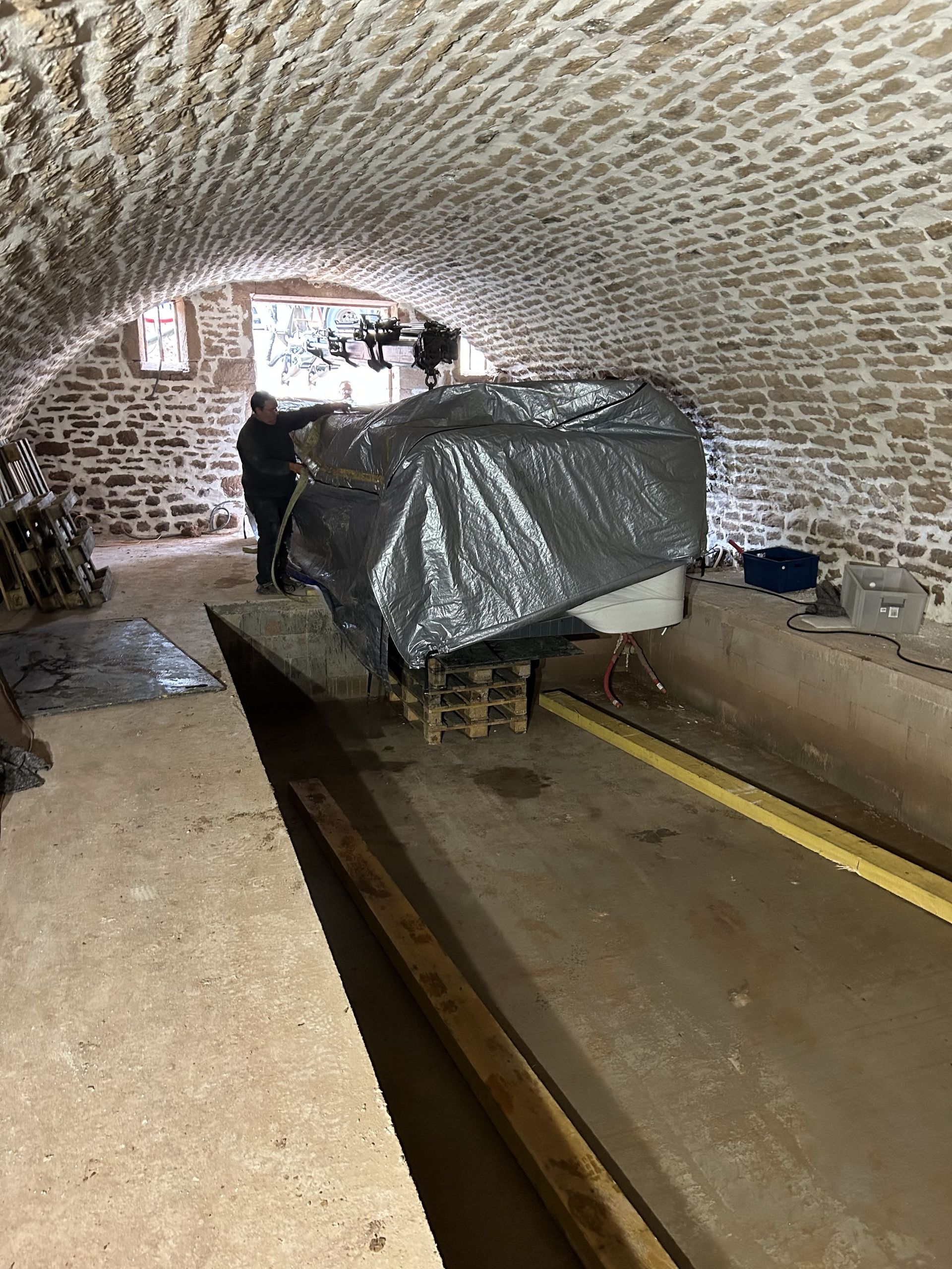 Un bateau est assis sur une palette dans un tunnel en briques.