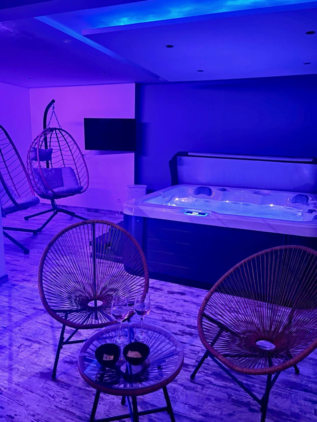 Il y a deux chaises et une table devant un bain à remous.