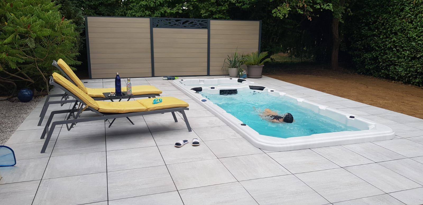 Un homme nage dans une piscine dans un jardin.