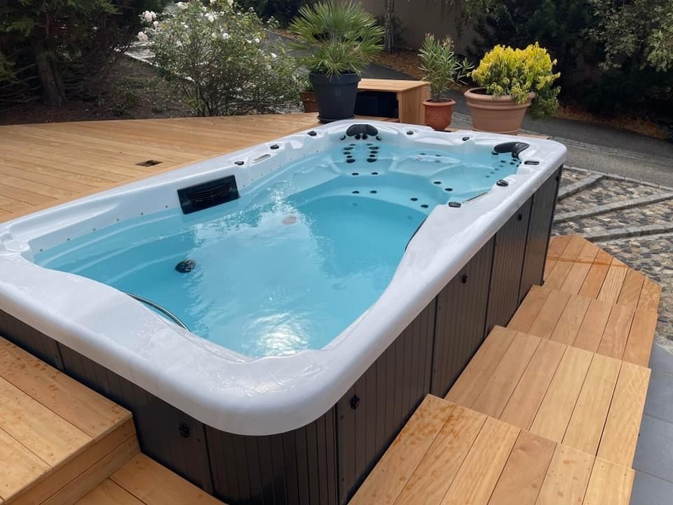 Un bain à remous est posé sur une terrasse en bois.