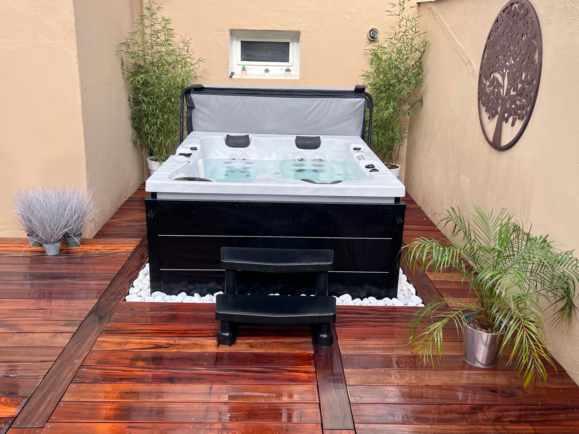 Un bain à remous est posé sur une terrasse en bois.