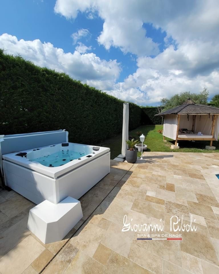 Un jacuzzi blanc se trouve sur un patio carrelé