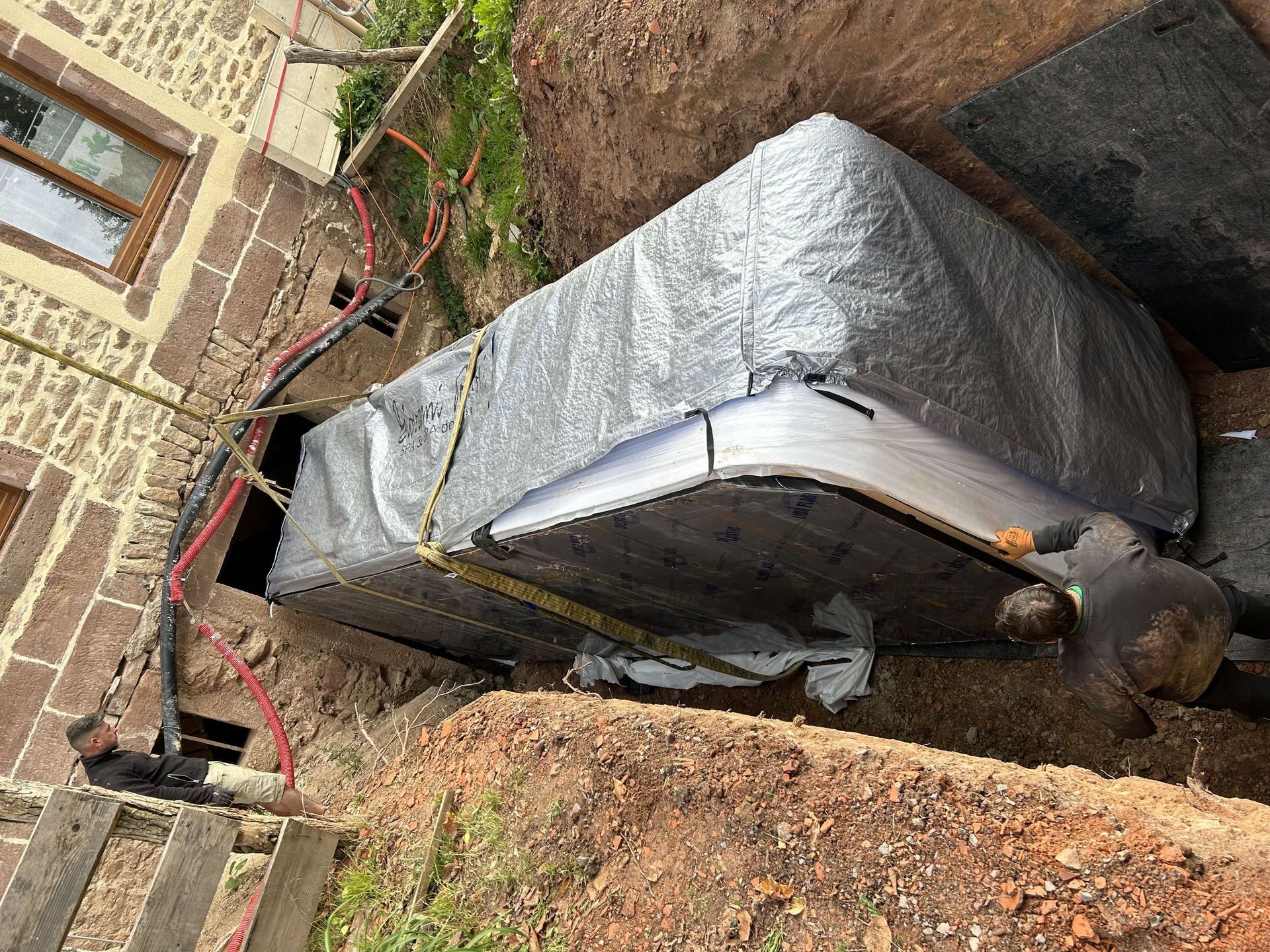 Un gros morceau de métal repose sur un tas de terre.