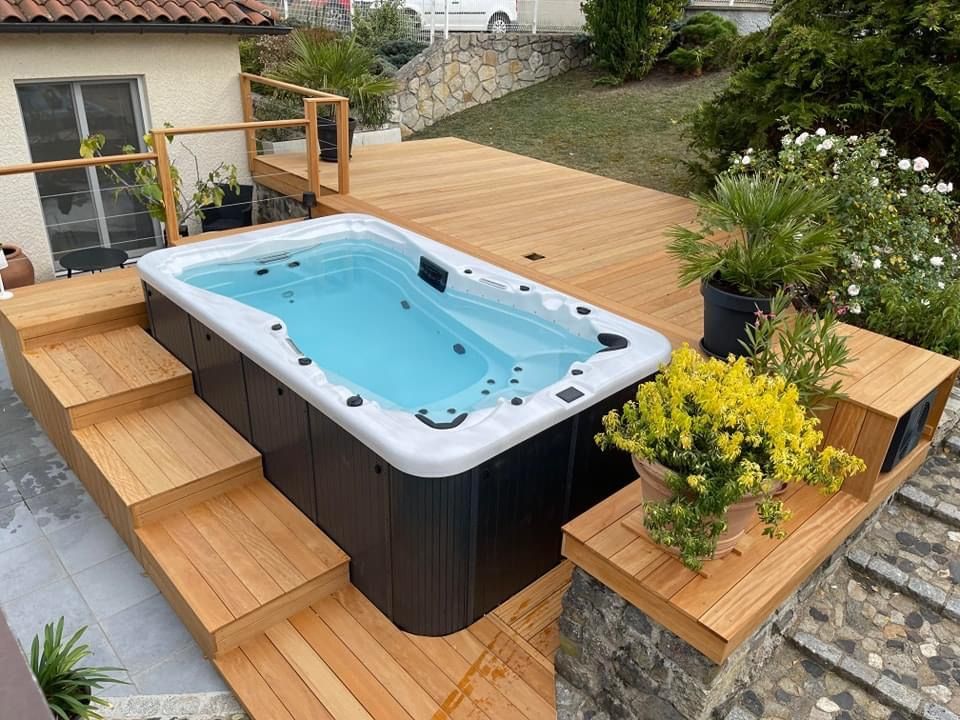 Un bain à remous est posé sur une terrasse en bois.