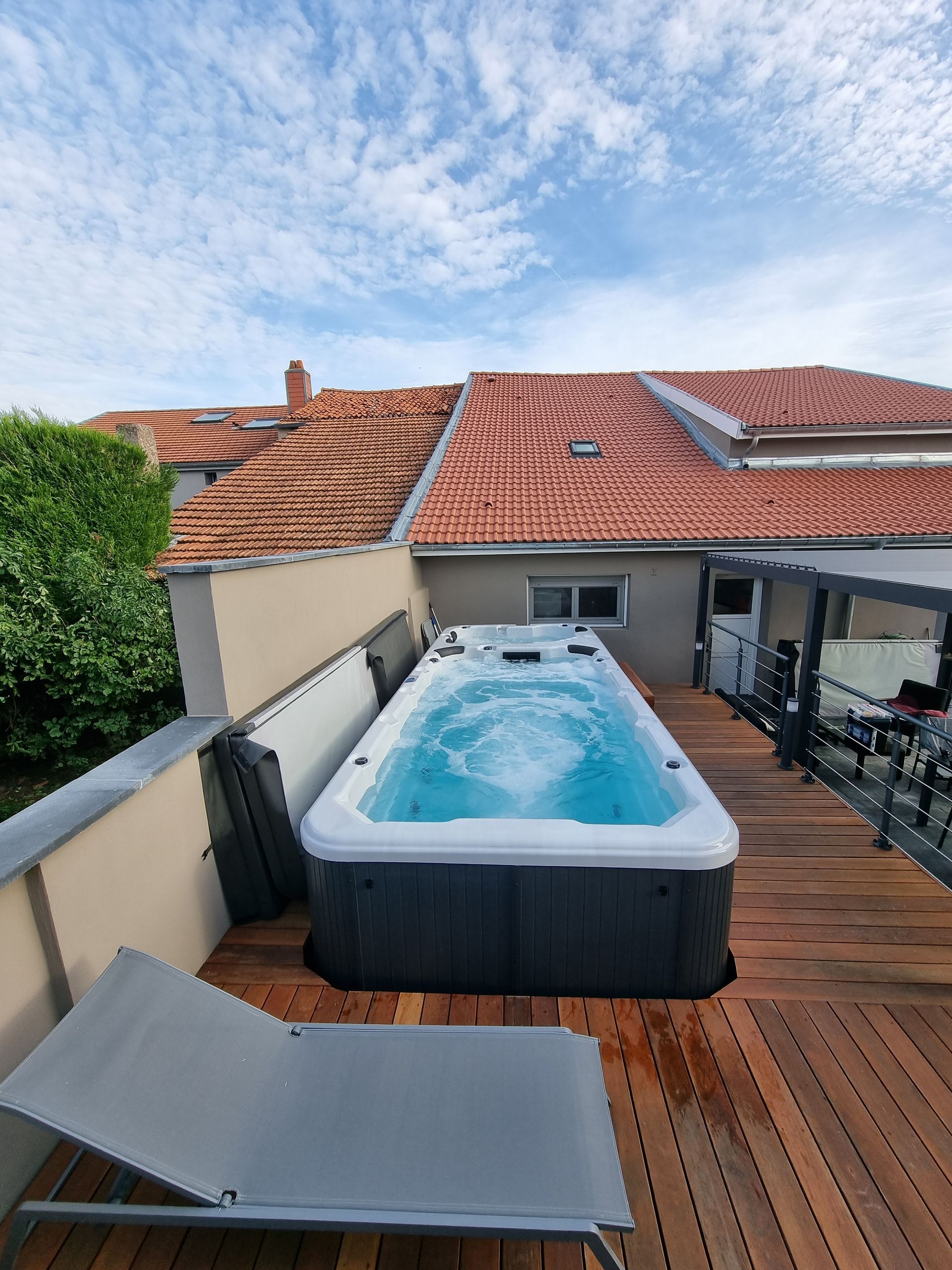 Un bain à remous est posé sur une terrasse en bois.