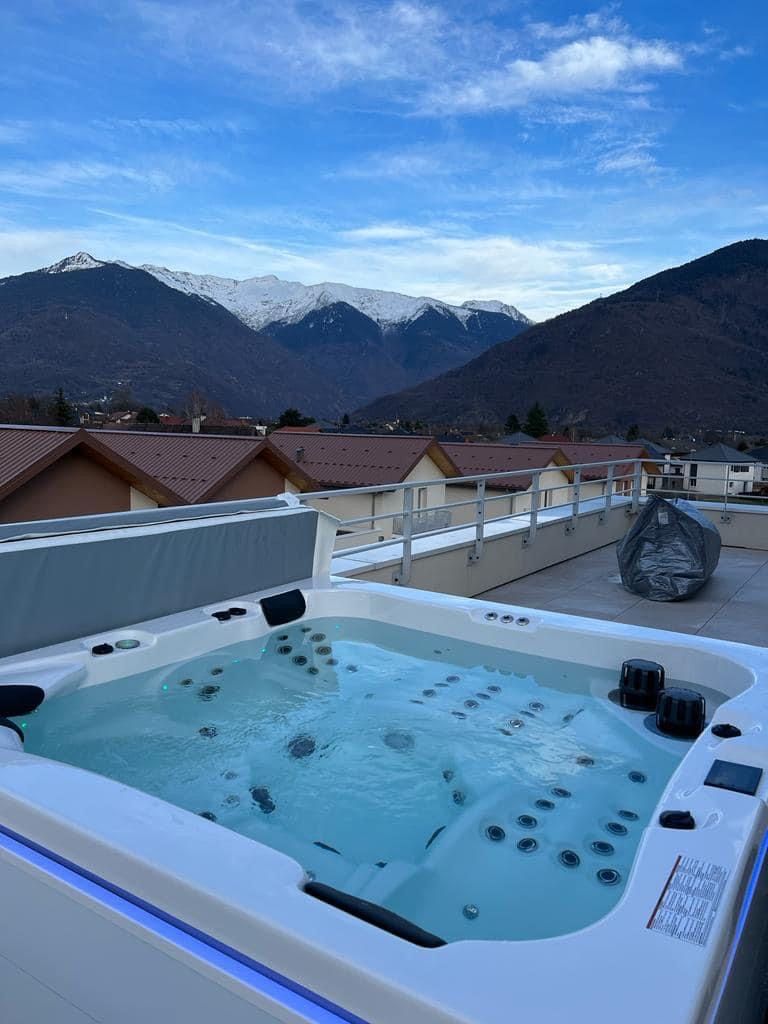 Un jacuzzi sur un toit avec des montagnes en arrière-plan.