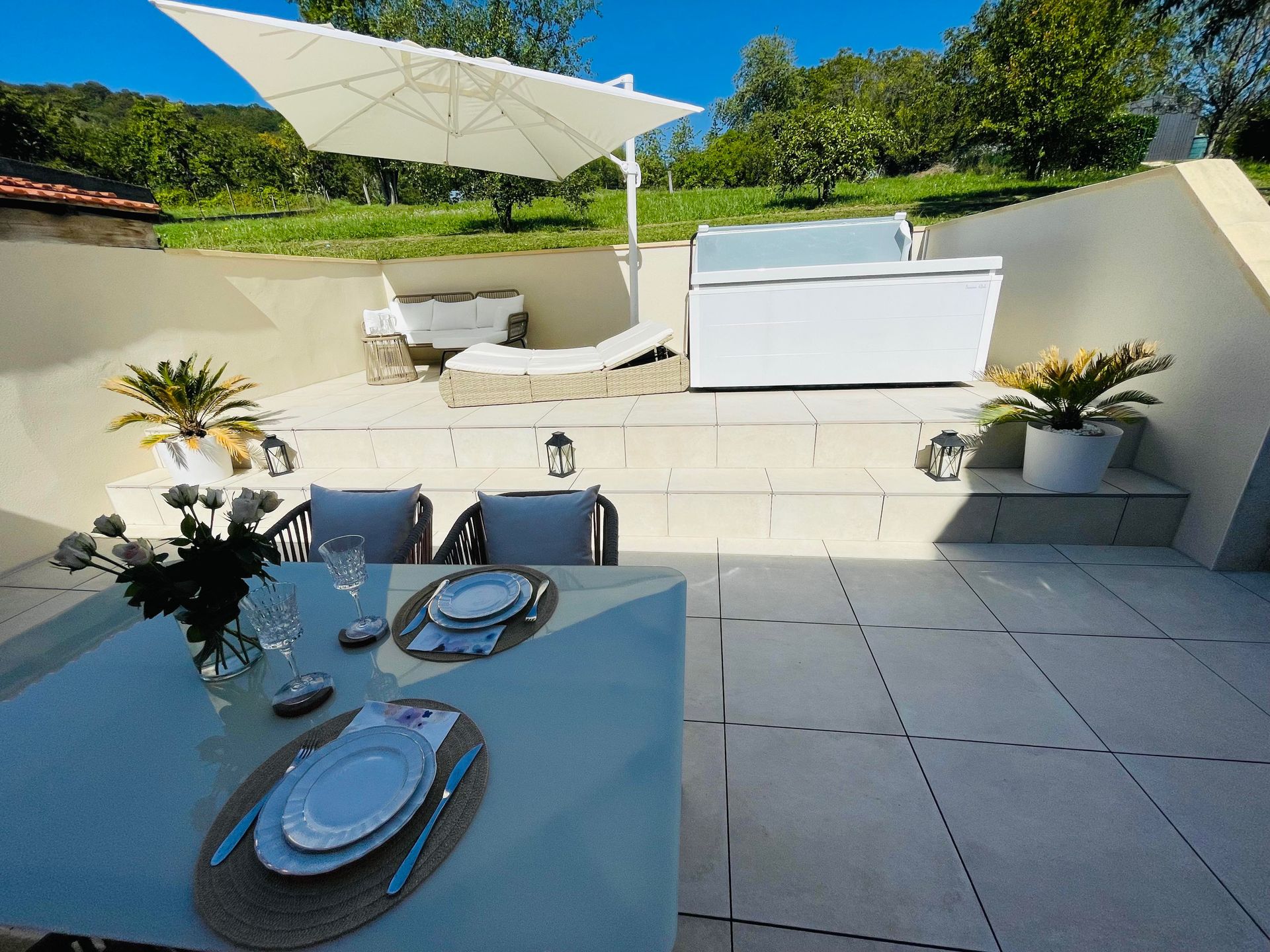 Un patio avec une table et des chaises sous un parasol