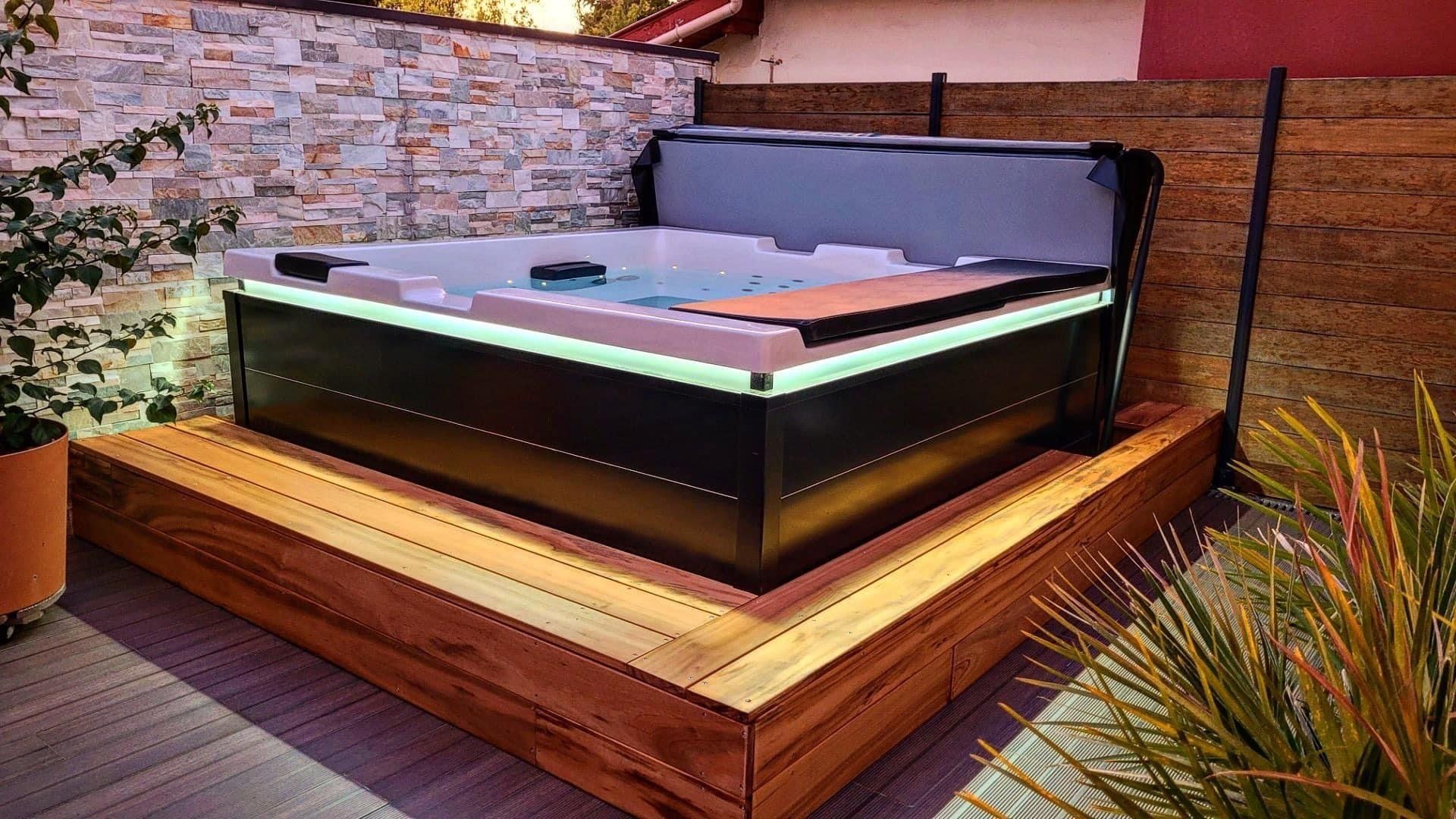 Un bain à remous est posé sur une terrasse en bois.