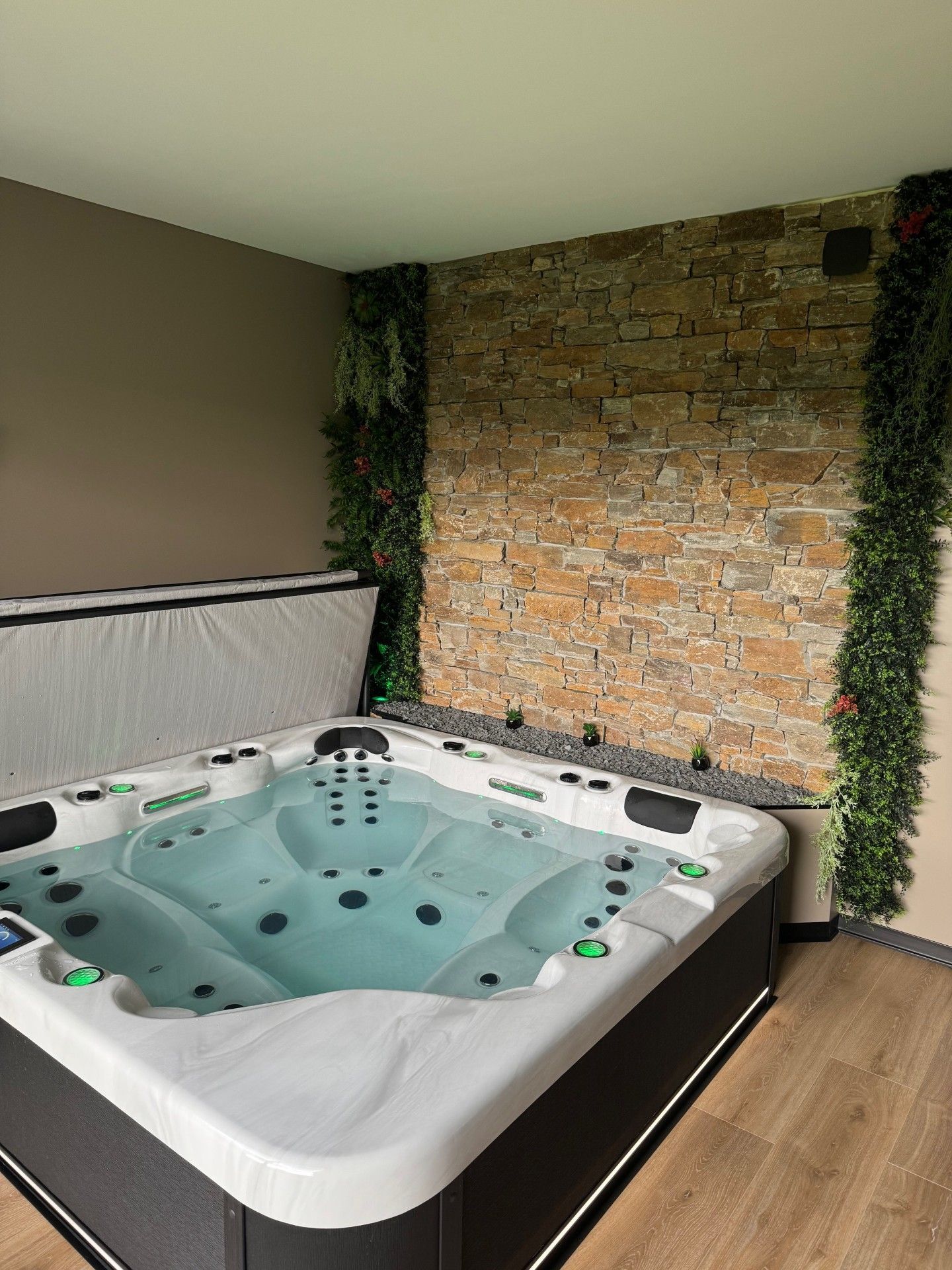 Un grand bain à remous se trouve dans une pièce à côté d'un mur de briques.