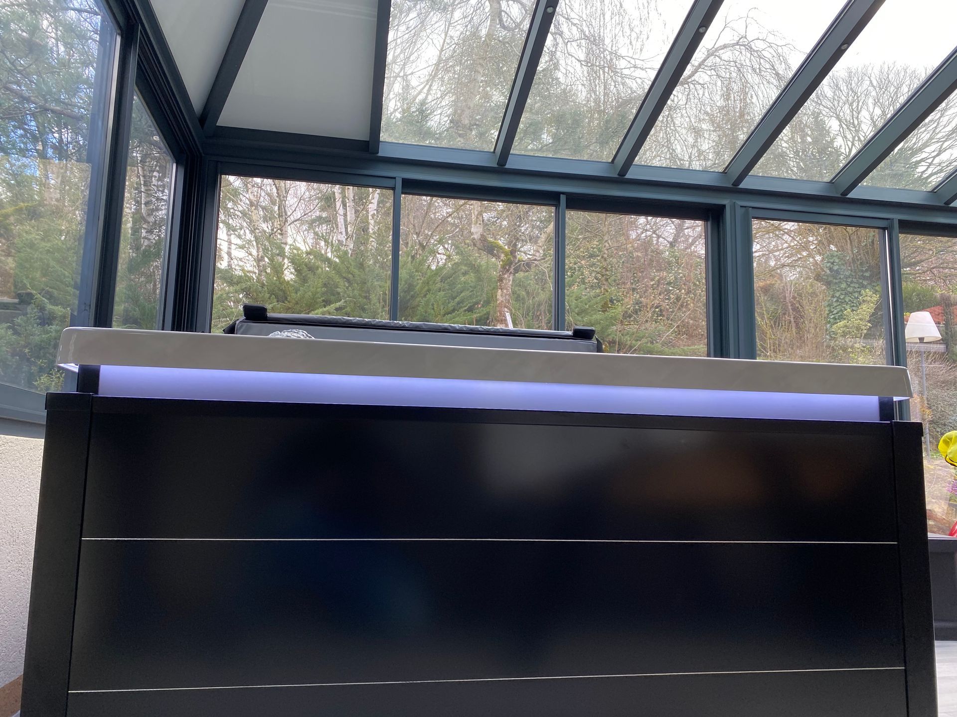 Un bureau noir dans une pièce avec beaucoup de fenêtres.