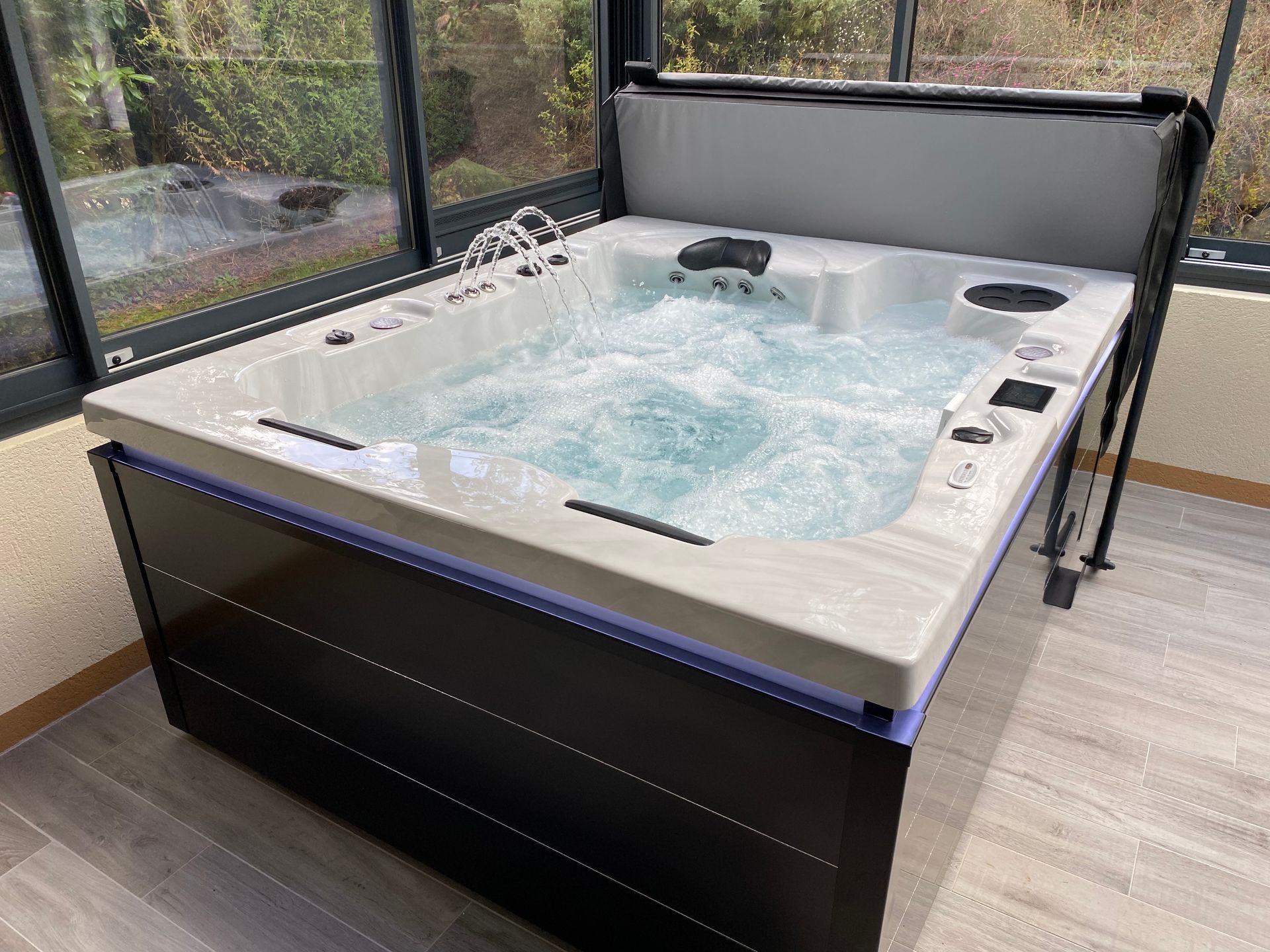 Un bain à remous est installé dans une pièce à côté d'une fenêtre.