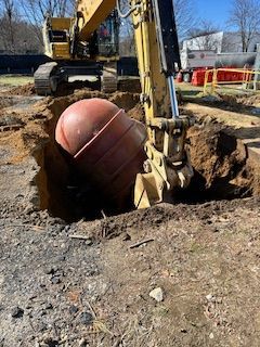 A yellow excavator is digging a hole in the ground.