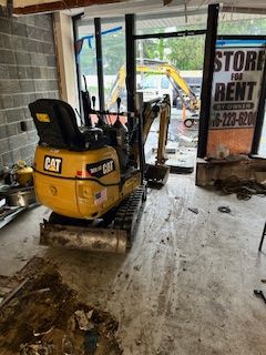 A small excavator is sitting in the middle of a room.