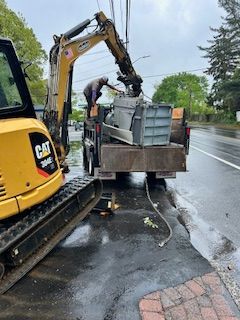 A man is loading a cat excavator into a truck.