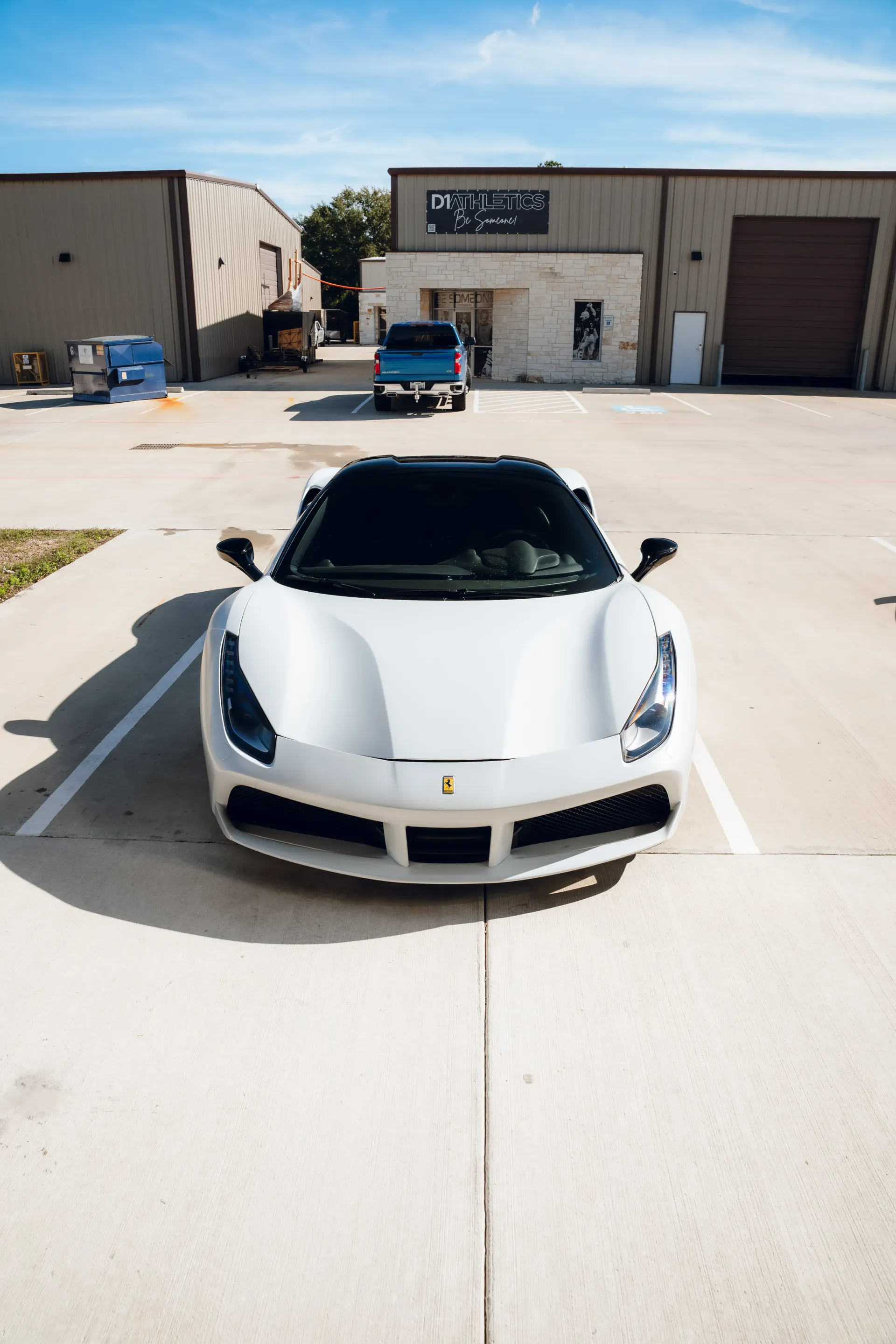 White Ferrari parked in front of a building on a sunny day. | Advance Automotive