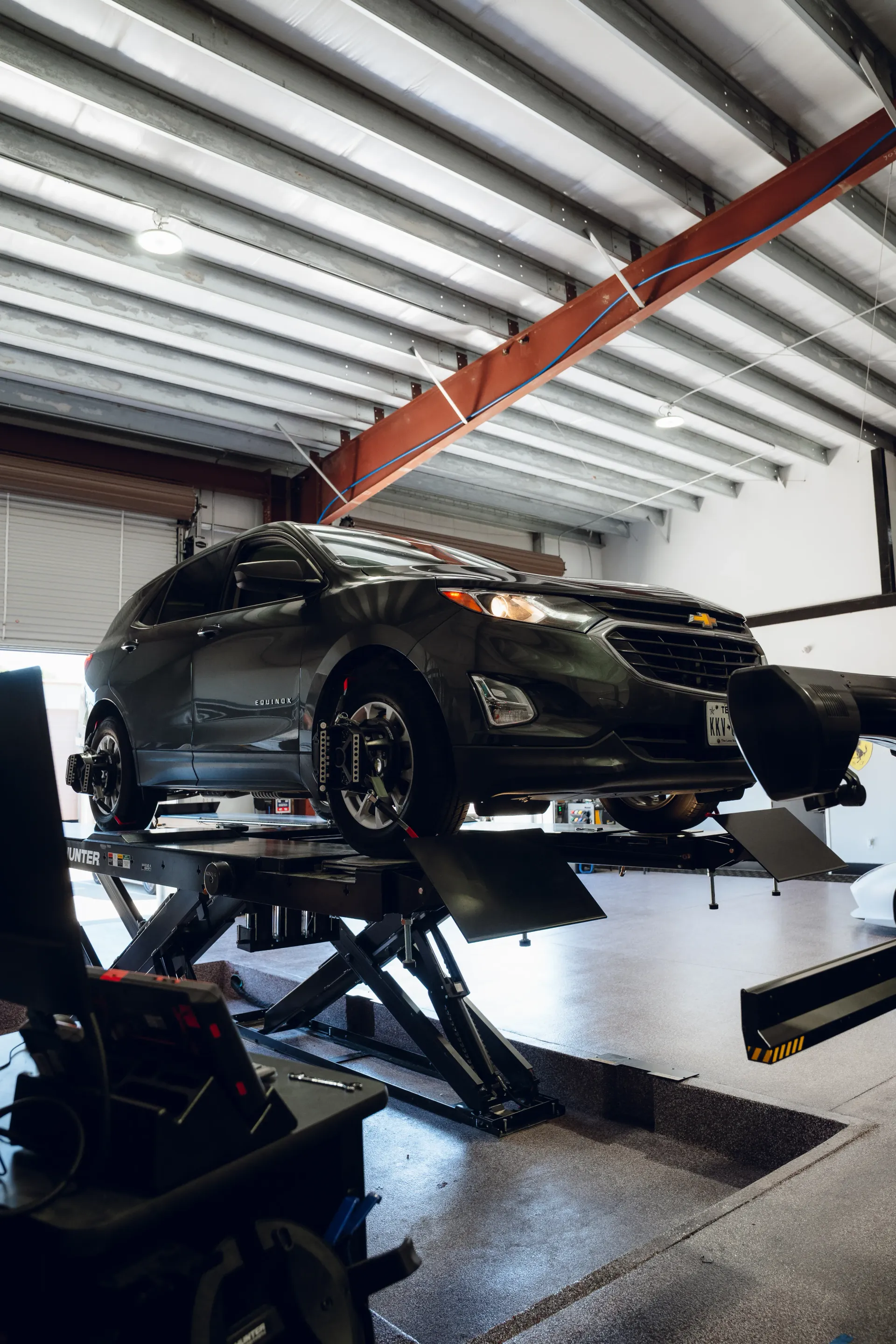 Dark gray SUV on a lift in a shop, being worked on. | Advance Automotive