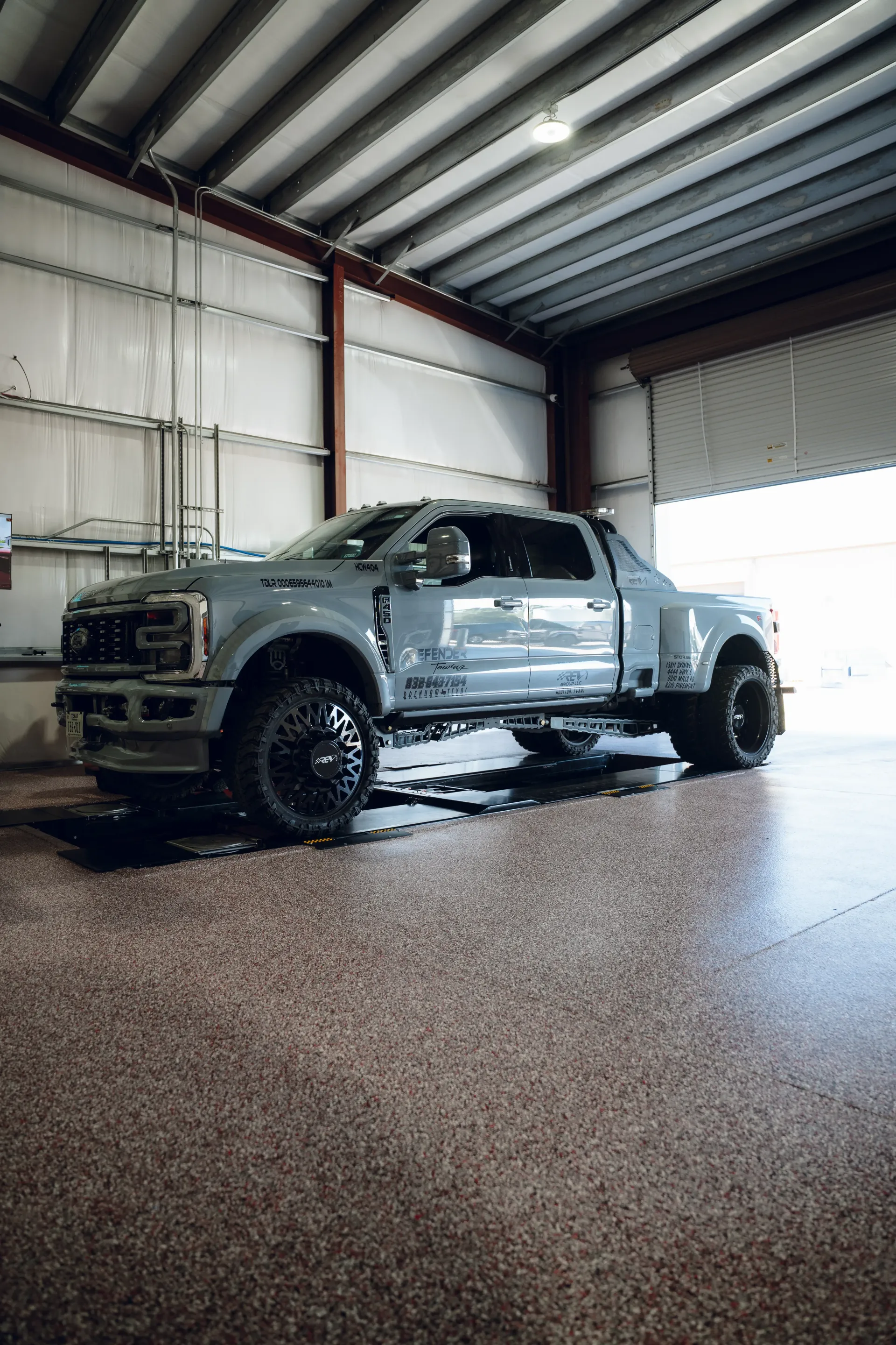 Grey Ford dually truck inside a garage. Black wheels, wet floor. | Advance Automotive