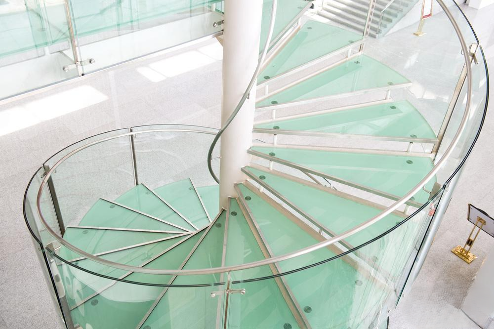 Teal metal handrails and balusters on gray concrete stairs