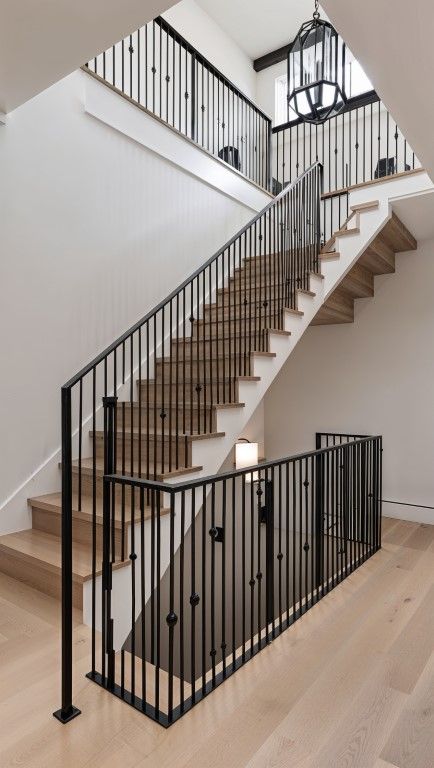 Wooden staircase with black metal railings in a well-lit, modern Casas Adobes home